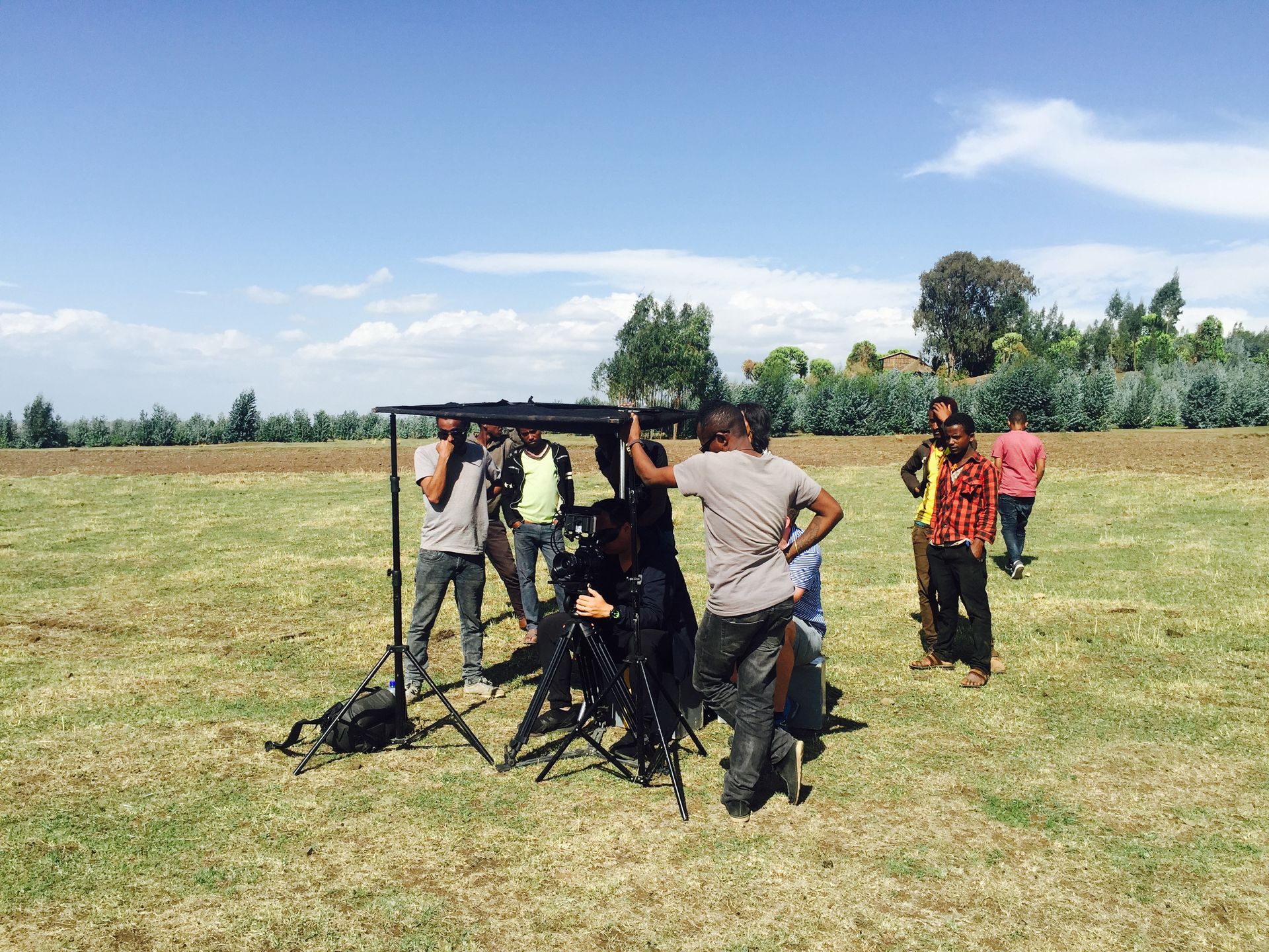 Film crew setting up cameras in open countryside in rural Ethiopia