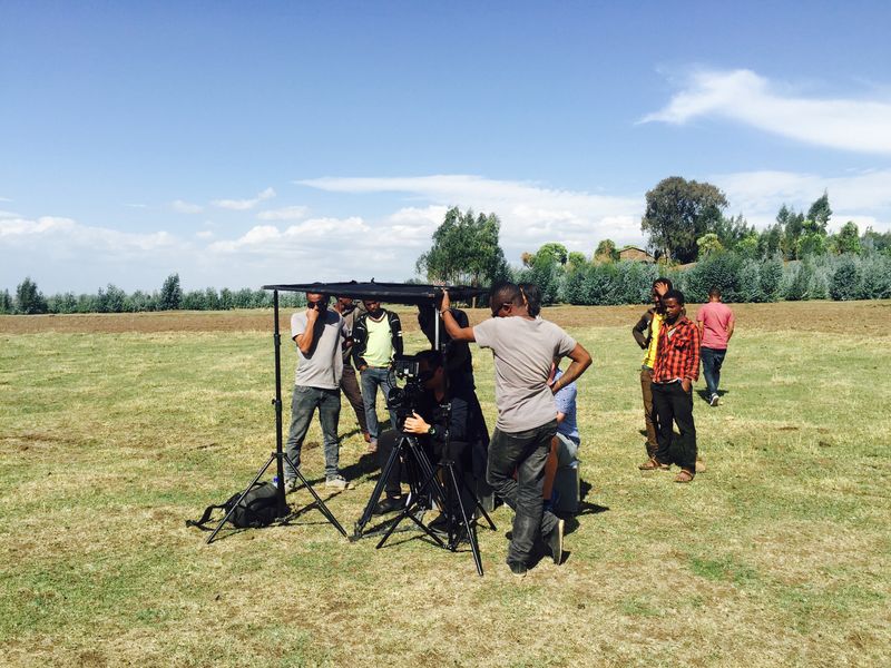 Film crew setting up cameras in open countryside in rural Ethiopia