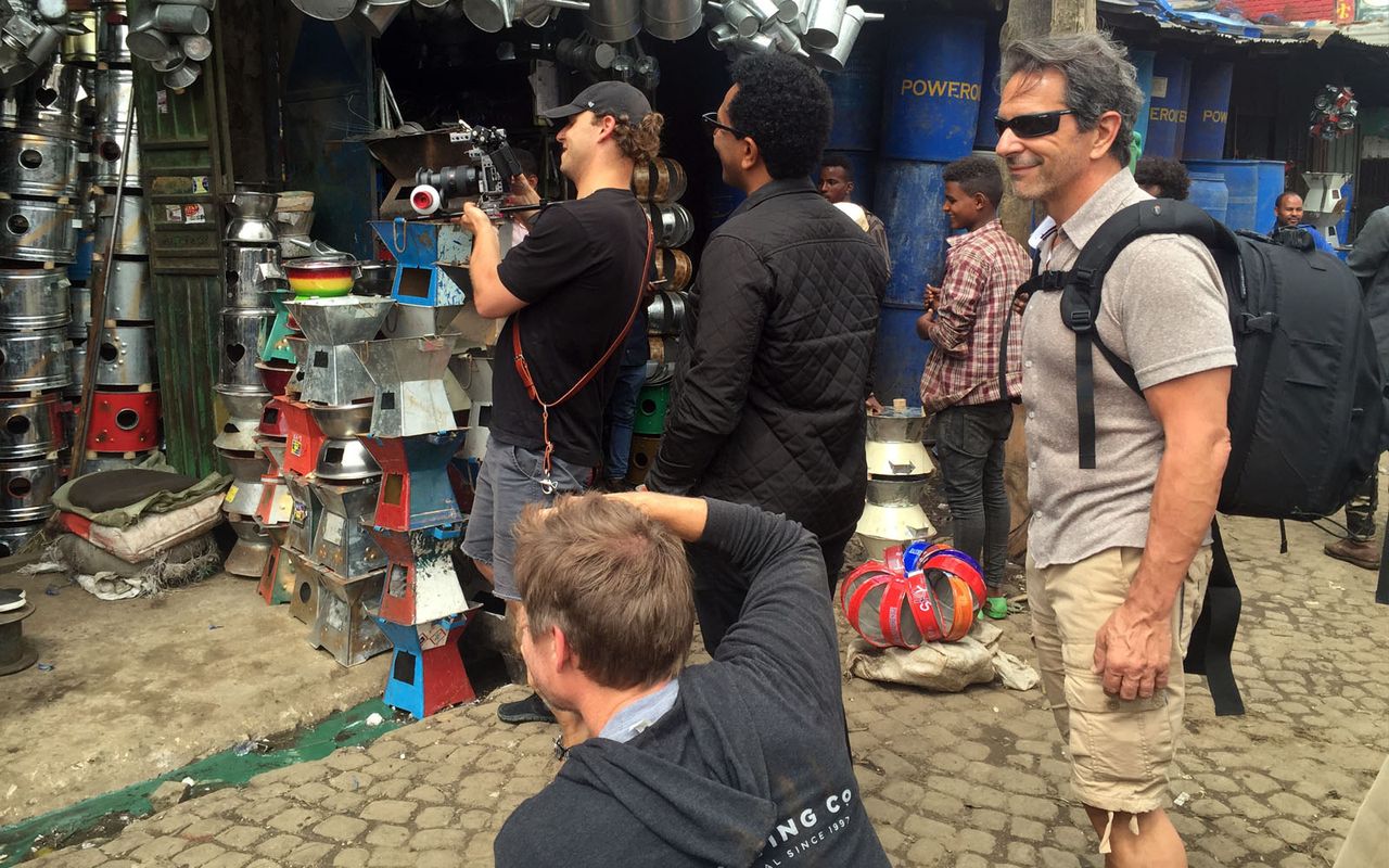 International crew filming among vendors in a busy Ethiopian market street with local fixer support